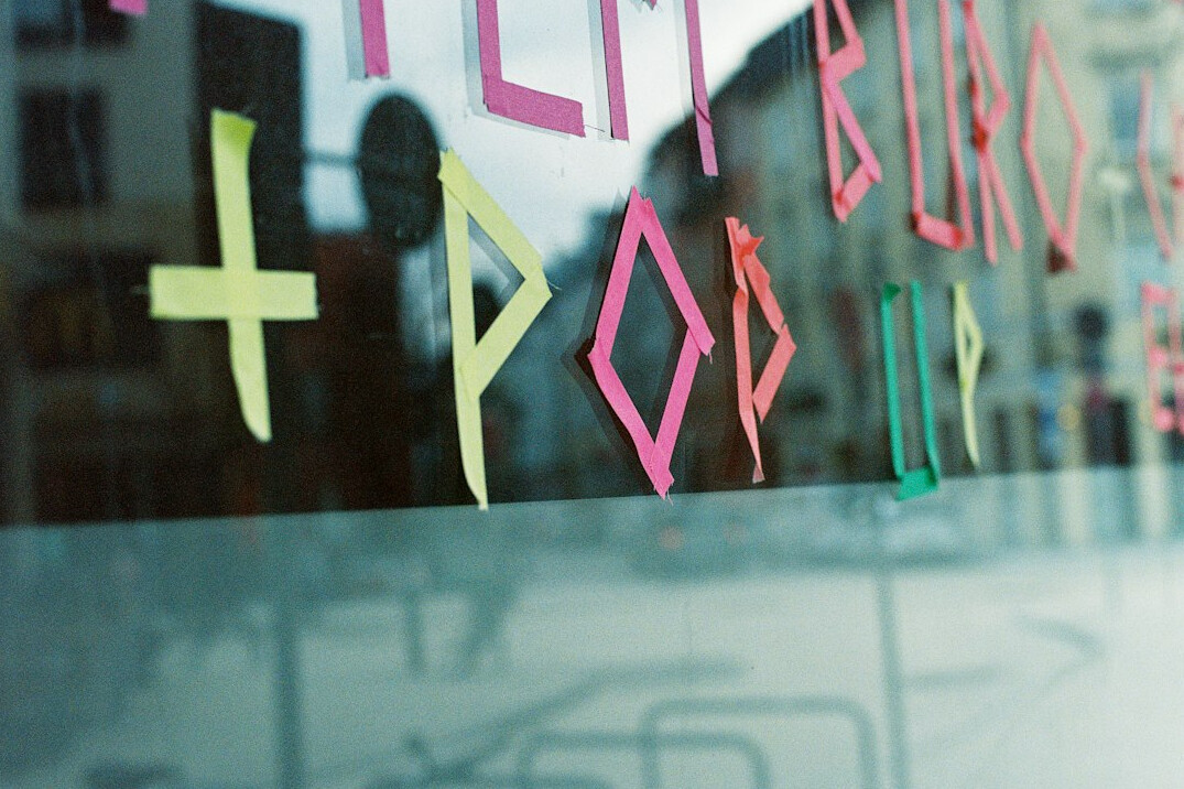 Facilitator leading a workshop with sticky notes on a glass wall